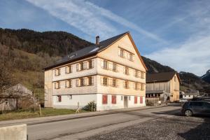 un grande edificio bianco sul lato di una strada di Ferienwohnung Gertrud a Bezau