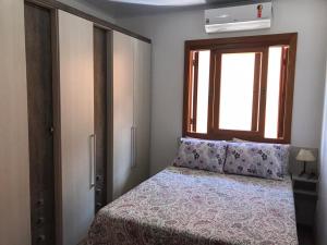 Un dormitorio pequeño con una cama y una ventana. en Residenciais Gramado Encantos, en Gramado