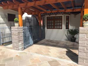 una casa con una puerta de madera y una valla en Residenciais Gramado Encantos, en Gramado