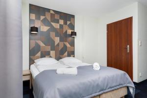 1 dormitorio con 1 cama grande y cabecero de madera en Nawigator SPA, en Rewal