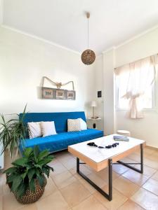 a living room with a blue couch and a table at Rena House in Kissamos