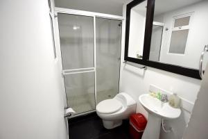 a bathroom with a shower and a toilet and a sink at Ayenda Apartamento Turistico Distrito 9 90 in Cali +29 photos