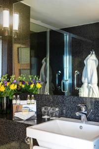 
a bathroom with a sink, mirror, and bathtub at St Giles London – A St Giles Hotel in London
