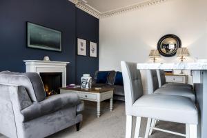 a living room with a couch and a chair at Fisherman's Catch - Two Bedroom Luxury Apartment - Tenby in Tenby