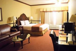 a hotel room with a bed and a couch at Folk Inn Ontario Airport in Ontario