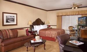 a hotel room with a bed and a couch at Folk Inn Ontario Airport in Ontario