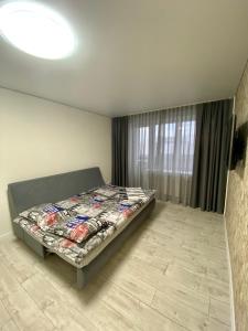a bedroom with a bed in a room with a window at Свіжа та стильна квартира! in Cherkasy
