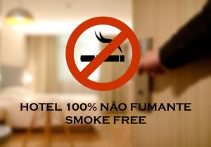 a sign with a no smoking sign in a room at Alameda Vitória Hotel in Vitória