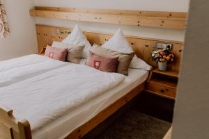 1 cama grande con sábanas y almohadas blancas en Hotel Zur alten Mühle, en Neuenbürg