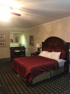a bedroom with a large bed with a red blanket at Folk Inn Ontario Airport in Ontario