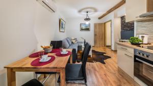 kuchnia i salon z drewnianym stołem i krzesłami w obiekcie Apartment Krajinovic w Zagrzebiu