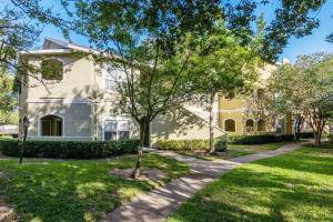 a large white house with trees in front of it at Gorgeous condo, 2 bedrooms, 2 baths, with pool, minutes to Clearwater Beach in Clearwater