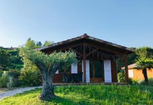 une petite maison avec un arbre en face dans l'établissement Les Chalets Montréjeau, à Montréjeau