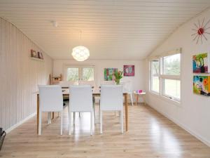 comedor con sillas blancas y mesa en 6 person holiday home in Bl vand, en Blåvand