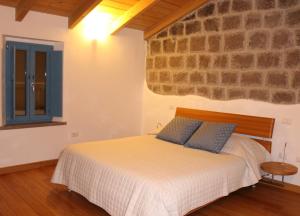 a bedroom with a bed and a stone wall at Sard Paradise in Ruinas