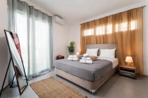 a bedroom with a bed and a large window at The Aristotelian Suites by Athens Stay in Athens