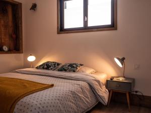 a bedroom with a bed with two lamps and a window at La Belle Landaise 1809 studio 4 couchages in Peyrehorade