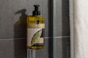a bottle of olive oil sitting next to a wall at The Aristotelian Suites by Athens Stay in Athens