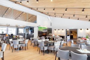 a restaurant with tables and chairs in a room at Blix Hotel in Vikøyri