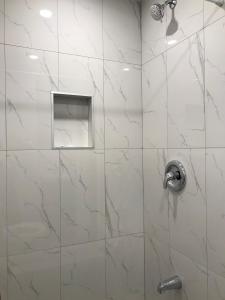 ducha con puerta de cristal y cabezal de ducha de plata en Hotel La Residence du Voyageur, en Montreal
