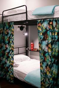 Ce lit superposé se trouve dans un dortoir doté d'un lit blanc. dans l'établissement NATIVUS Art-Hostel, à San José