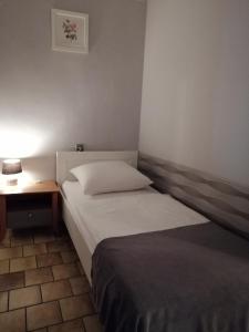 a hotel room with two beds and a lamp on a table at Zajazd pod Różą in Zielona Góra