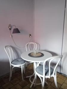 a white table with two chairs and a lamp at Zajazd pod Różą in Zielona Góra