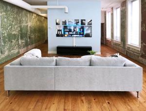 a large couch in a living room with a television at Downtown Salon - Location - Comfort - Style in Atlanta