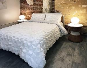 Un dormitorio con una gran cama blanca con dos lámparas. en Downtown Retreat - Location - Comfort - Style, en Atlanta