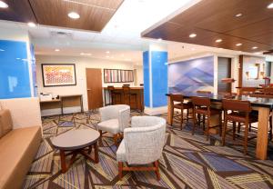 a lobby with chairs and tables and a bar at Holiday Inn Express & Suites - Forney by IHG in Forney