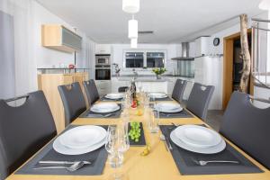 einen Esstisch mit weißen Tellern und Besteck in der Unterkunft Tolles Einfamilienhaus nahe dem Bodensee in Lauterach