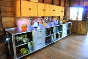 a kitchen with a counter with cabinets and a counter top at Cabaña La Kirita EcoHotel in Bahía Solano +56 photos