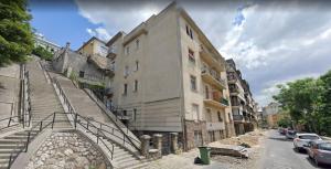 a building with stairs next to a street with cars at Amber Dream in Budapest