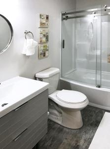 Un baño blanco con inodoro y ducha. en Downtown Retreat - Location - Comfort - Style, en Atlanta