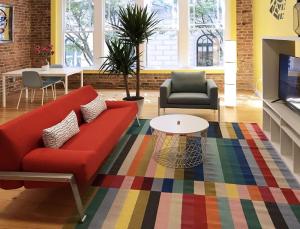 a living room with a red couch and a colorful rug at Downtown Vibration - Location - Comfort - Style in Atlanta