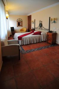 
a hotel room with two beds and a chair at Hotel Santo Domingo de Silos in Santo Domingo de Silos
