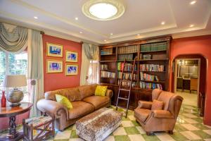 a living room with a couch and a book shelf at Mac Atini Guest House in Mbabane