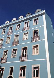 Saldanha Apartment في لشبونة: مبنى أزرق عليه نوافذ وشرفات