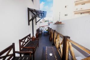 une rangée de bancs sur le côté d'un bâtiment dans l'établissement Economy Suites, à Natal