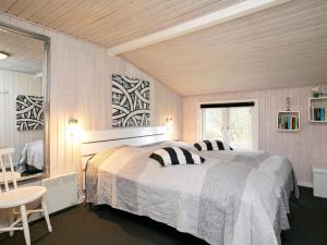 um quarto com 2 camas, uma mesa e uma janela em 6 person holiday home in Bl vand em Blåvand
