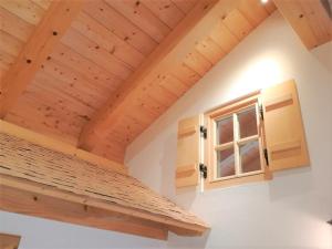 a room with wooden ceilings and a window at AlpStern Ferienwohnung in Oberstdorf