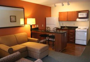 ein Wohnzimmer mit einem Sofa und einer Küche in der Unterkunft Affordable Suites - Fayetteville/Fort Bragg in Fayetteville