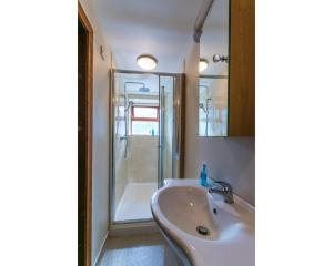 a bathroom with a sink and a shower at Tyncellar Farm holiday cottages in Margam