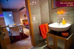 a bathroom with a sink and a room with a bedroom at bed & breakfast filderstadt by heller in Filderstadt