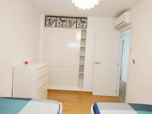 1 dormitorio con paredes blancas y armario blanco en Apartamento Cruise Views, en Almuñécar