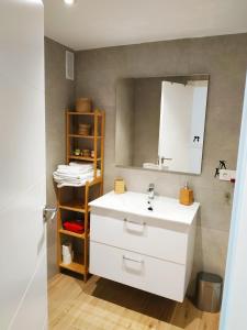 La salle de bains est pourvue d'un lavabo blanc et d'un miroir. dans l'établissement Apartamento Cruise Views, à Almuñécar