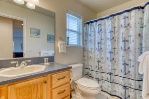 a bathroom with a toilet sink and a shower curtain at Pine Beach House in Rockaway Beach +19 photos