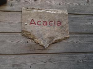 a sign on a wooden wall with the word acacia at Acacia in Cherbonnières