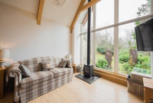 a living room with a couch and a large window at The Armoury in Glenfinnan