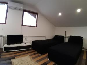 a living room with a couch and a flat screen tv at Apartments In Heart in Sarajevo